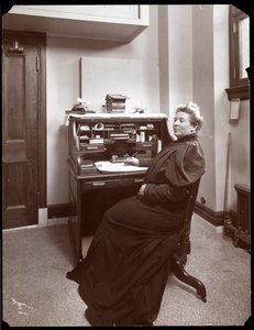 Portret van een niet-geïdentificeerde vrouw aan een bureau in een kantoor in New York, 1904